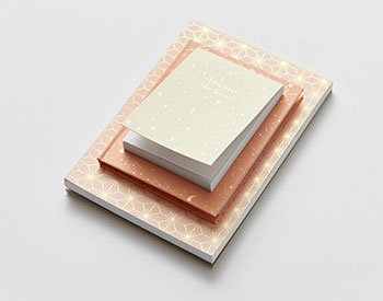 image of three orange and pink notepads stacked on top of each other