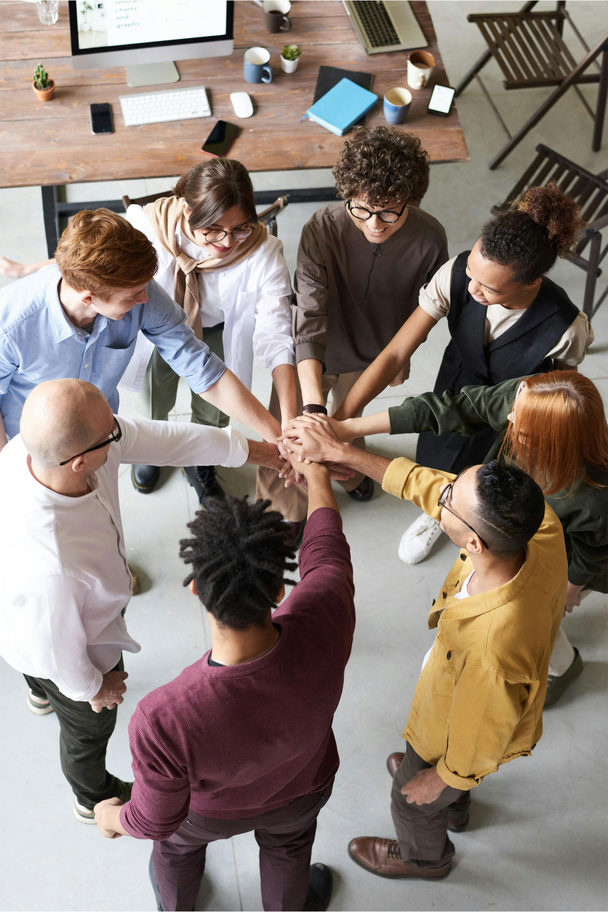 image of a group of people placing their hands toegether