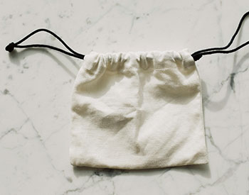 small white cinch bag with black draw strings image